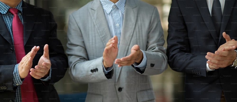 Successful executive manager or businessmen in formal suit clapping their hands in the meeting. Congratulations, greeting welcoming, achieve goals.