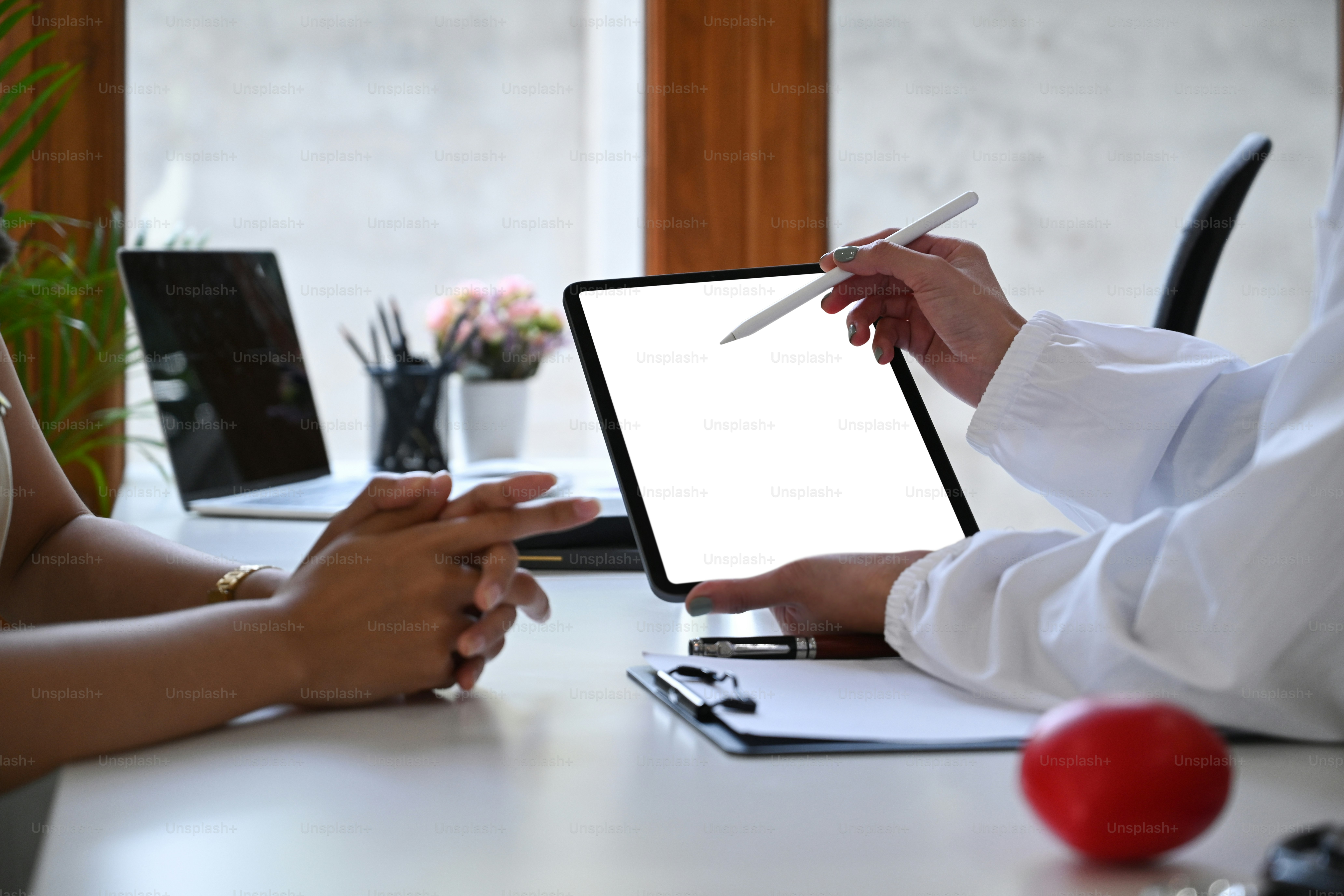 Cropped Shot Arzt hält digitales Tablet und diskutiert medizinische Informationen mit dem Patienten.