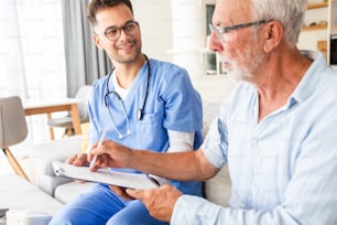 Male nurse talking to seniors patients while being in a home visit.