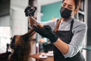 Gros plan d’une femme se faisant couper les cheveux chez un coiffeur pendant la pandémie de coronavirus.
