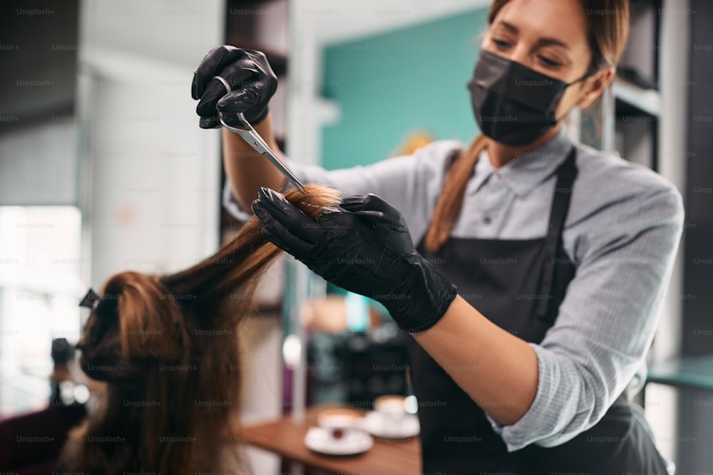 Close-up de mulher fazendo corte de cabelo em cabeleireiro durante pandemia de coronavírus.