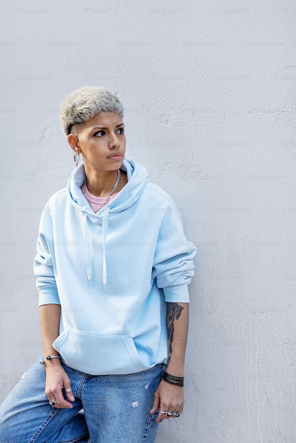 fonds stikstof Reageren Fashionable young woman wearing blue hoodie and jeans posing on the city  wall. blonde girl in short hairstyle. photo – Spain Image on Unsplash