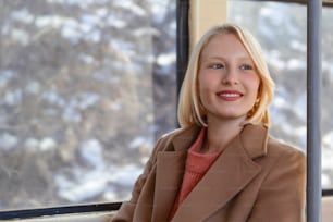 Pendolare che sogna ad occhi aperti sull'autobus. Ritratto di una donna all'interno di un autobus. Passeggero felice dell'autobus che viaggia seduto su un sedile e guarda attraverso il finestrino. Ritratto di passeggero sorridente della donna che si siede nell'autobus pubblico