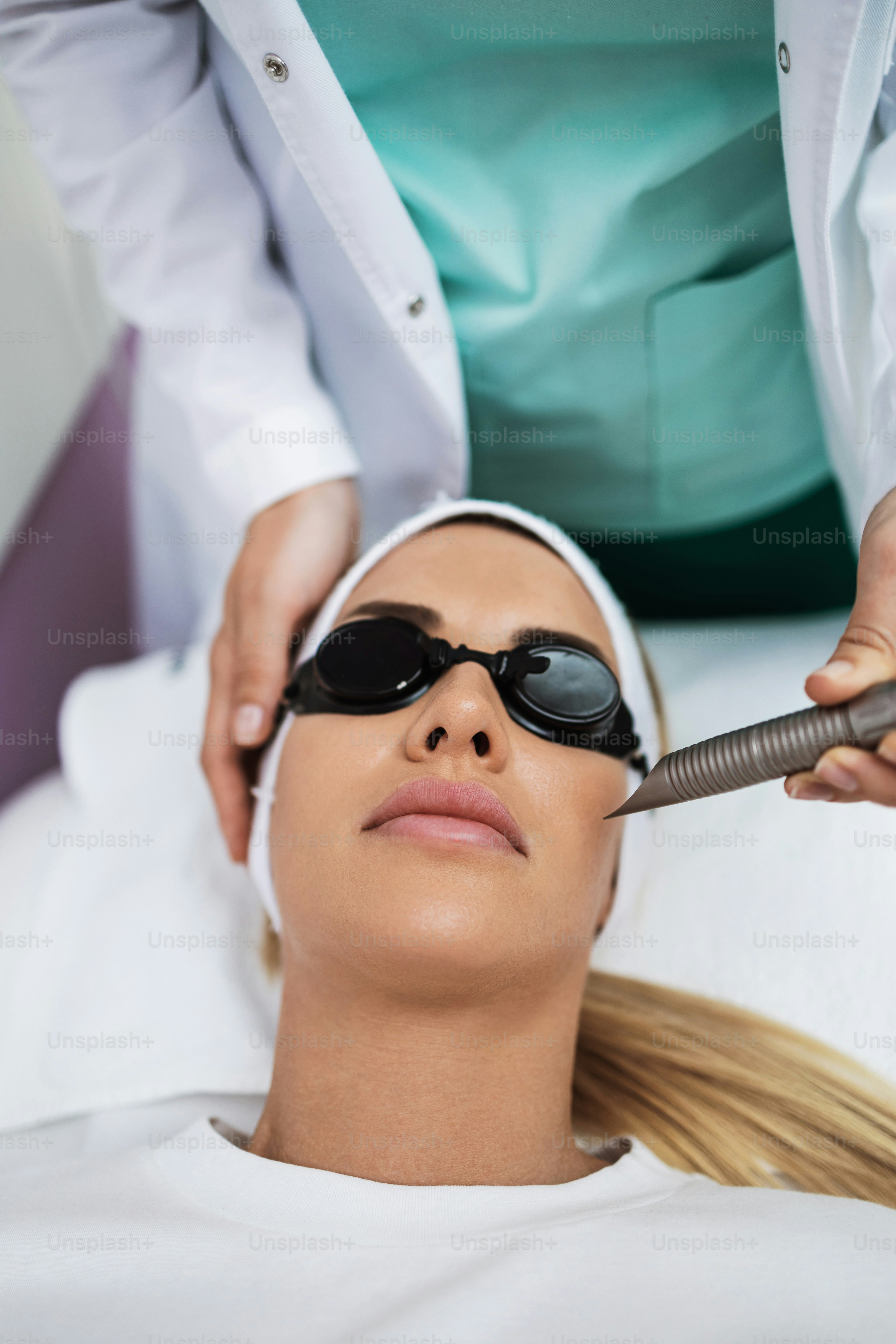 Beautiful young female patient receiving modern medical and beauty. Permanent facial and body hair removal with gamma waves diode laser.