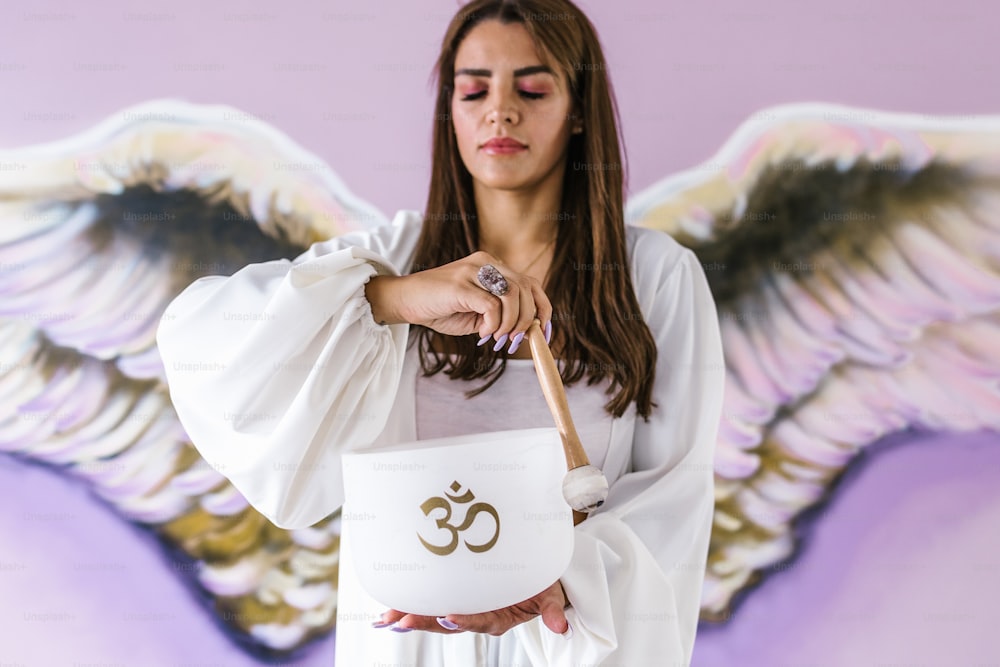 Junges lateinamerikanisches Mädchen spielt Kristallklangschalen, um in Lateinamerika zu meditieren