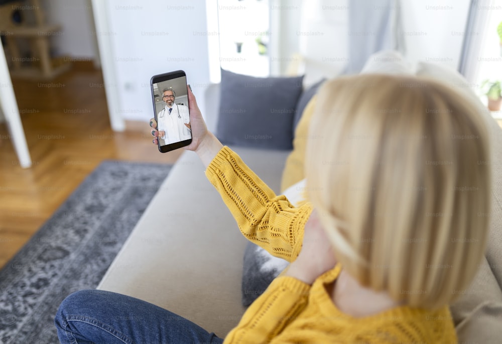 Close up of a young woman talking to her doctor on a video call