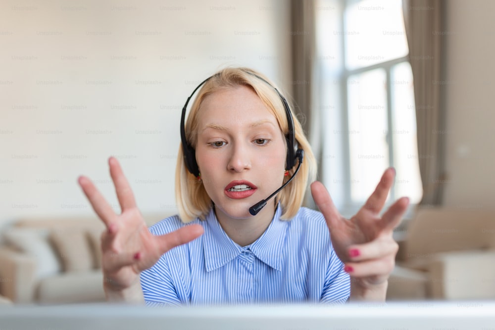 Portrait of blond woman doing video call using laptop. Businesswoman with headset talking during online meeting with colleague. Albino woman working from home over a video conference on computer.