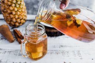 Tepache mexican Fermented pineapple drink and hand holding a Jar with kombucha homemade probiotic superfood sliced pineapple beverage in Mexico city