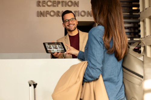 Recepcionista de hotel asistiendo a un huésped
