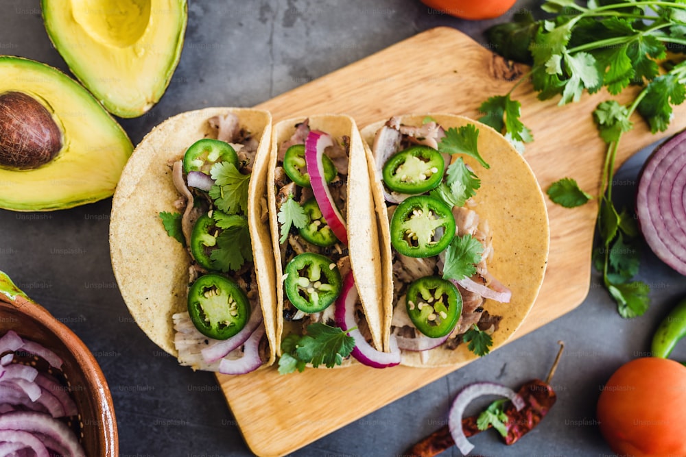 mexican street tacos ingredients with pork carnitas, tortillas, avocado, onion, cilantro in Mexico city