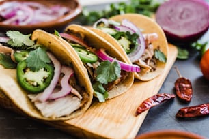 mexican street tacos ingredients with pork carnitas, tortillas, avocado, onion, cilantro in Mexico city