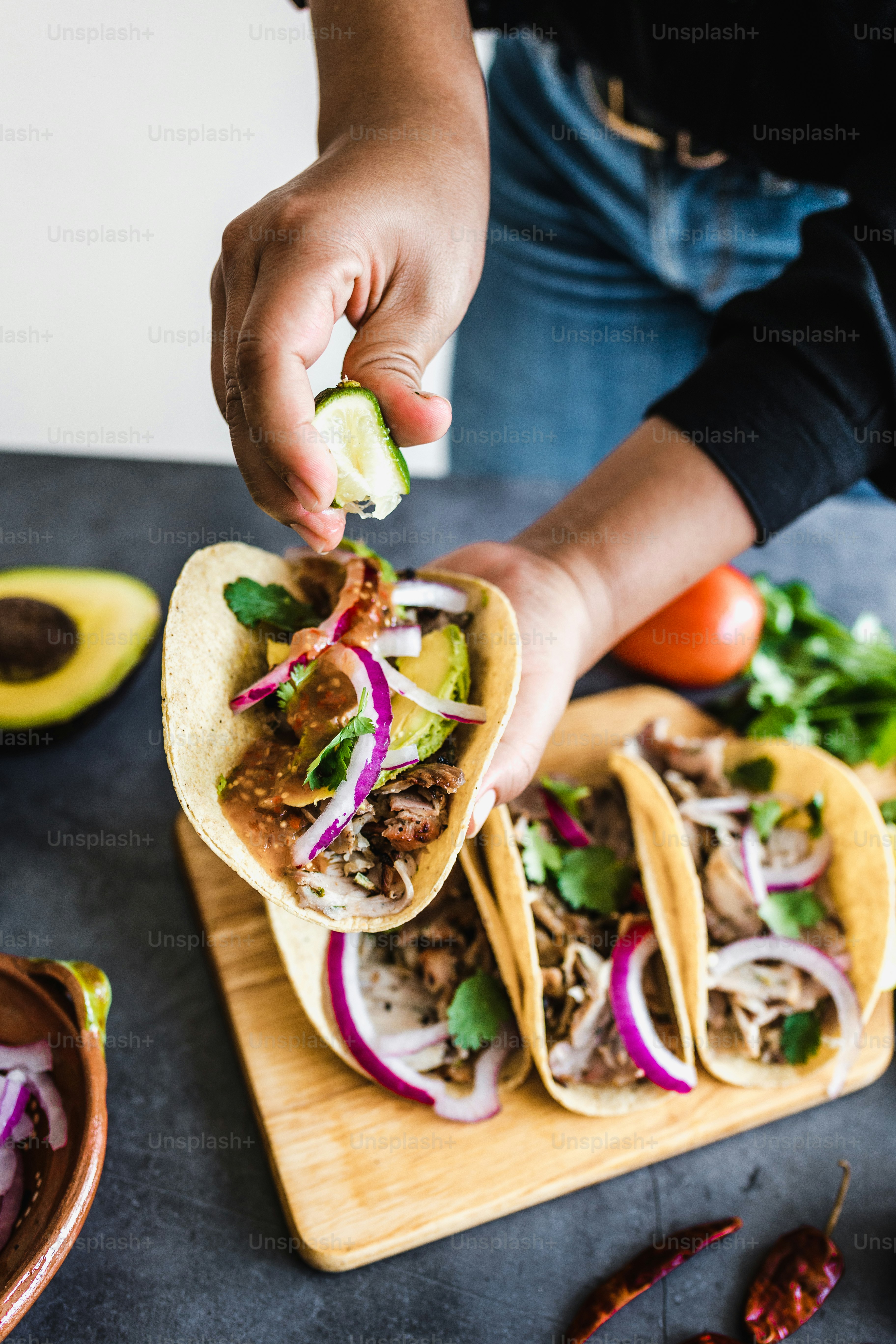 Foto zum Thema Lateinische Frauenhände bereiten mexikanische Tacos mit ...