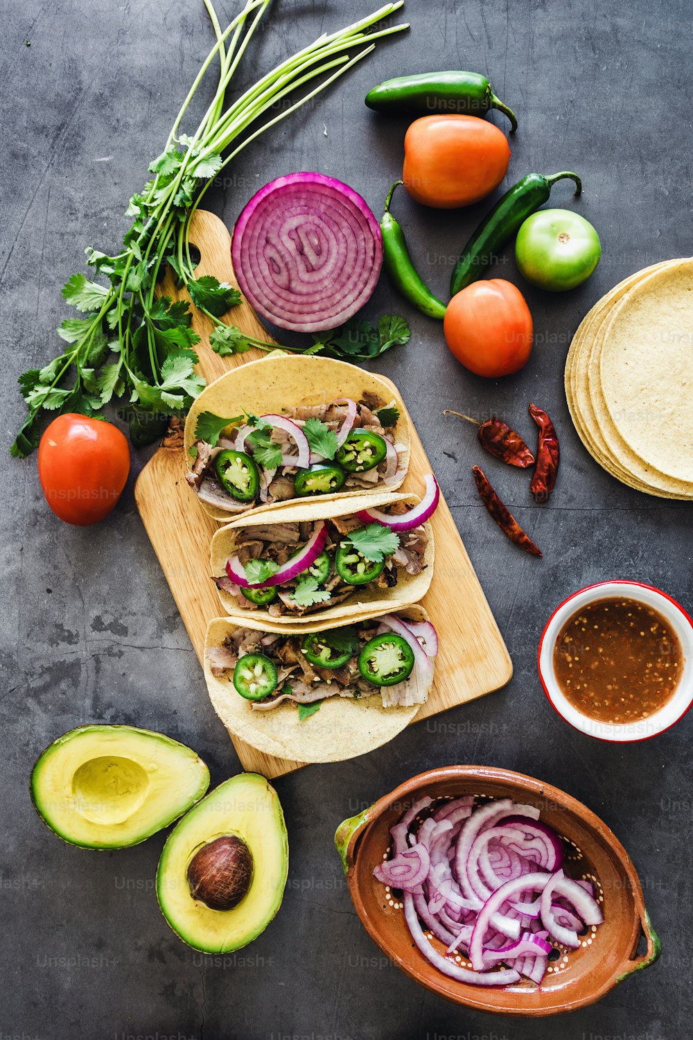 mexikanische Straßen-Tacos Zutaten mit Schweinefleisch-Carnitas, Tortillas, Avocado, Zwiebeln, Koriander in Mexiko-Stadt