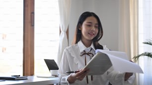 Young asian woman office worker checking financial report at office.