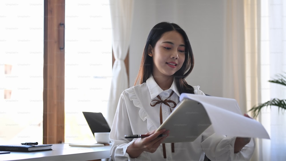 Young asian woman office worker checking financial report at office.