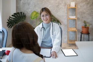 Asian female doctor explaining, discussing medical checkup result with patient.