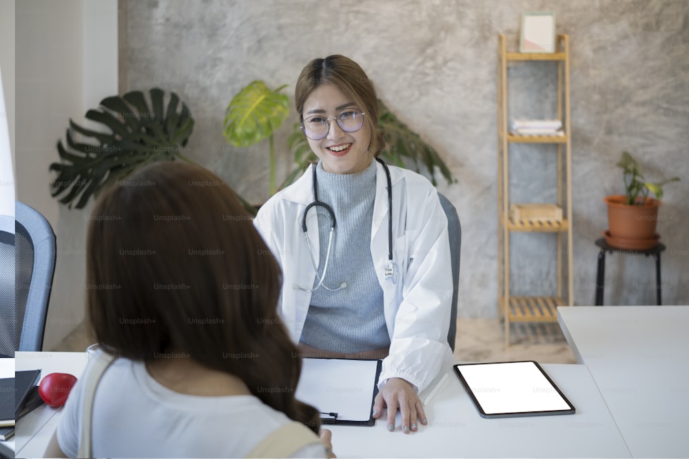 Asian female doctor explaining, discussing medical checkup result with patient.