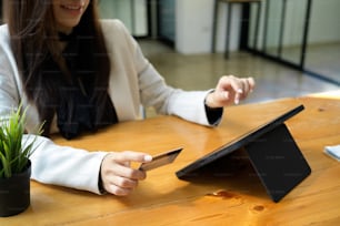 A female, office worker or businesswoman paying credit card expense on digital tablet computer. online payment, money transfer, cashless payment