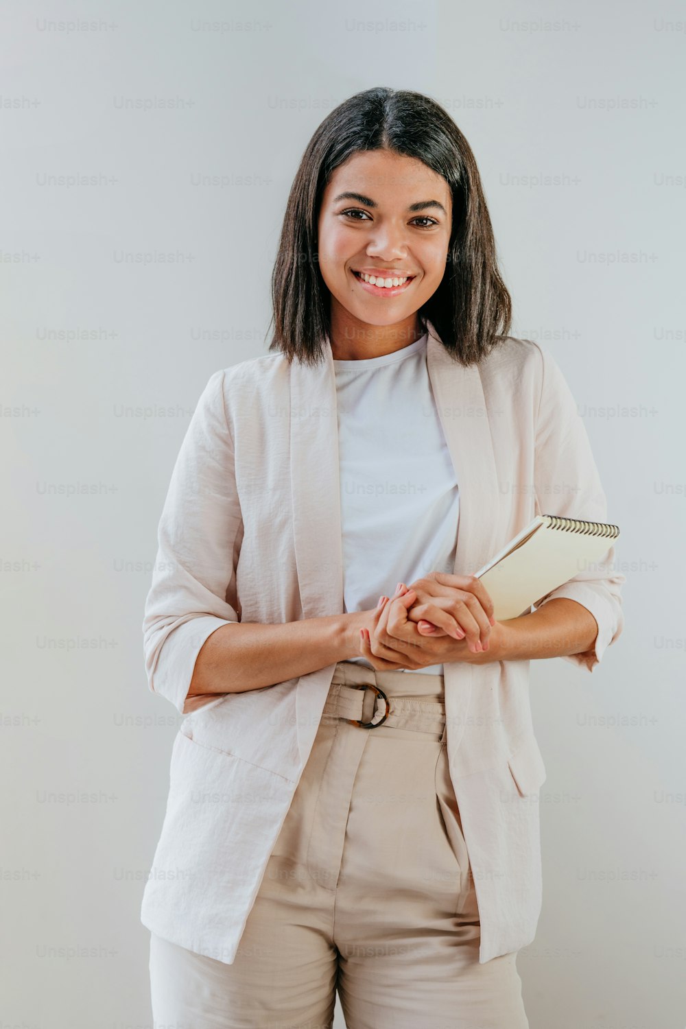 Young business woman wearing beige jacket standing working in the office.