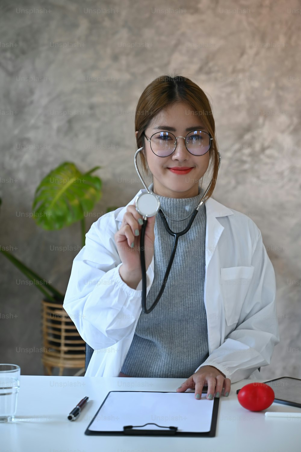 Belle femme médecin en uniforme blanc avec stéthoscope souriant à la caméra. Soins de santé et concept médical.