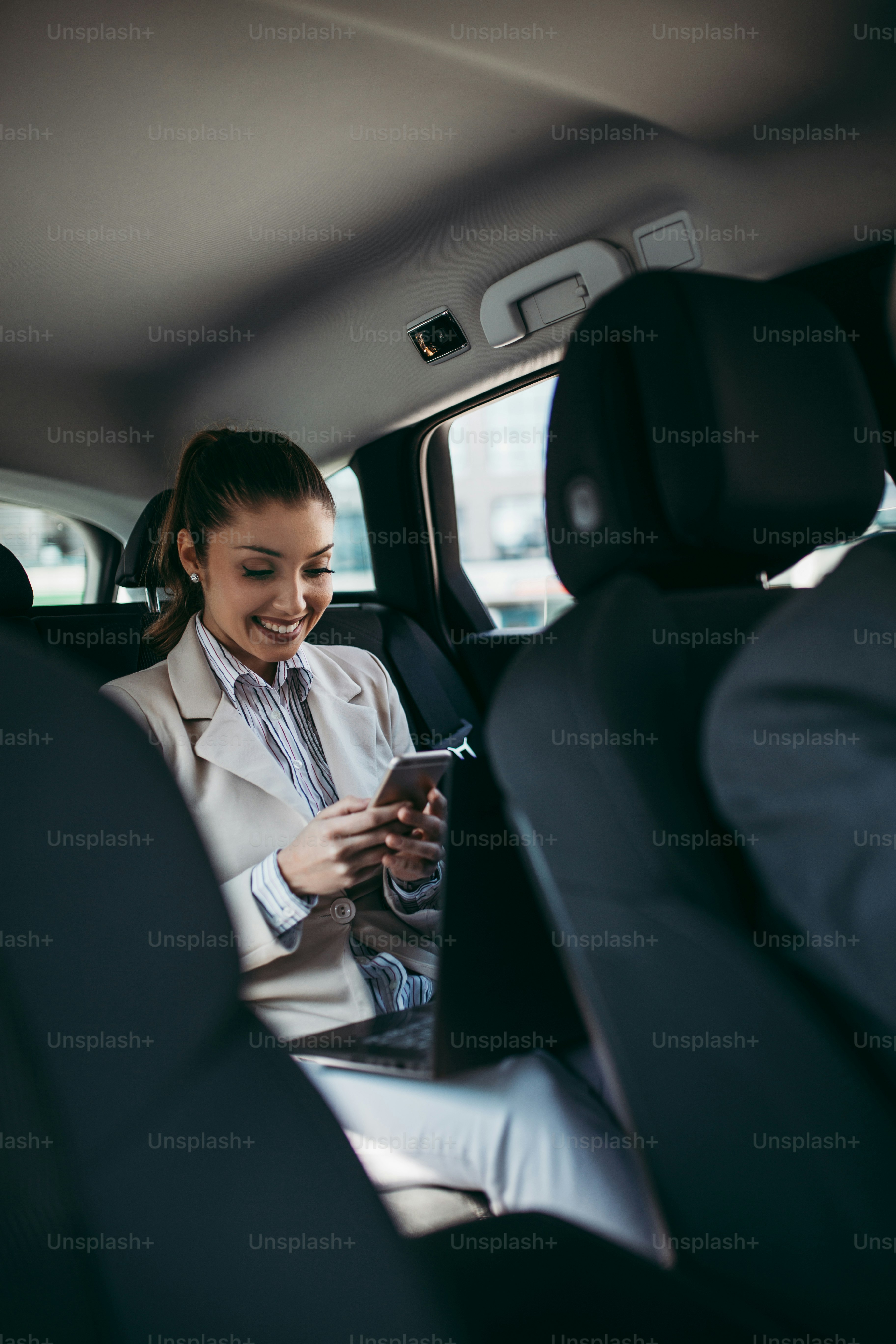Pengemudi senior yang tampan dan pengusaha muda duduk di kursi belakang di mobil mewah. Mereka berbicara dan tersenyum. Transportasi dalam konsep bisnis perusahaan.