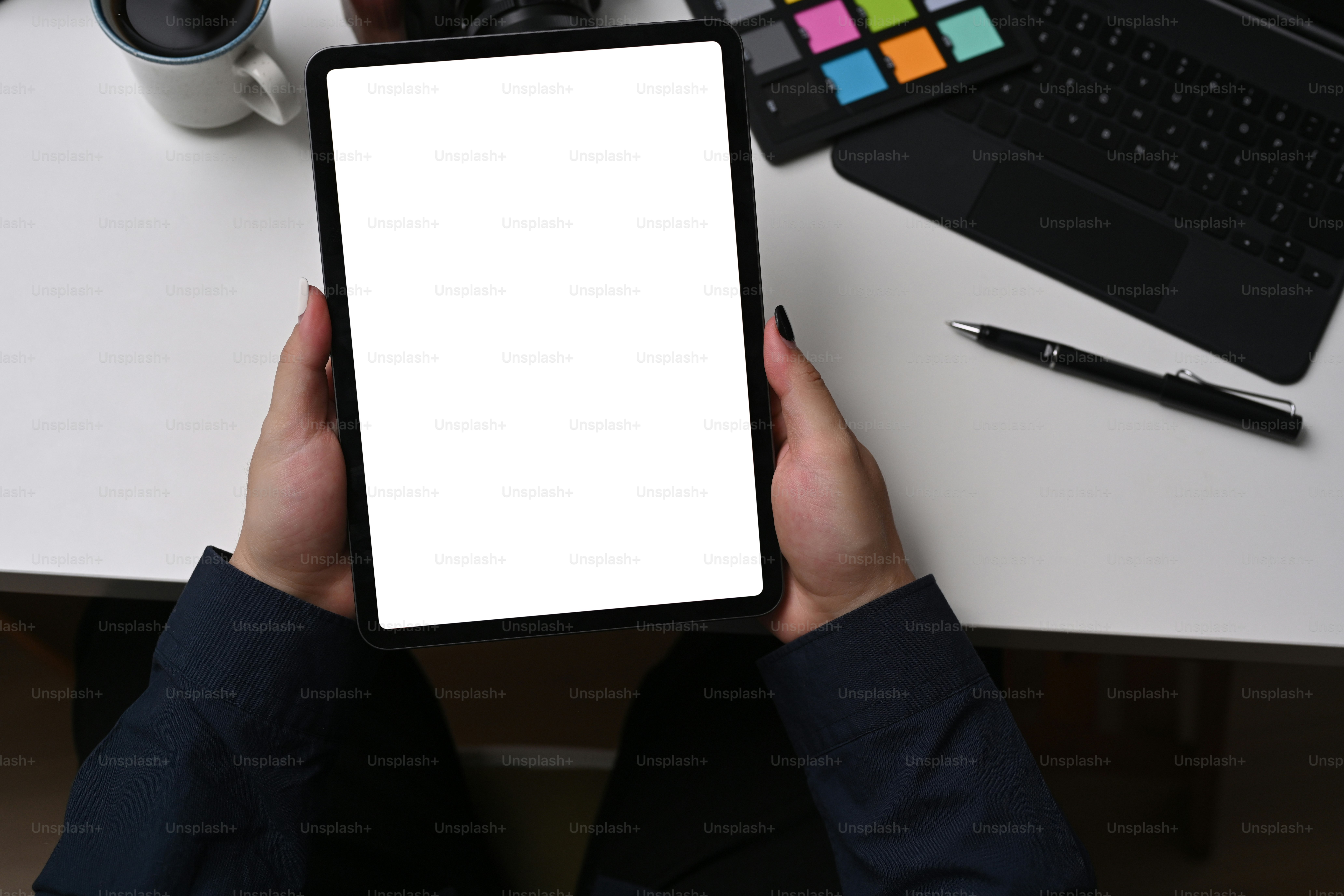 Gros plan : un graphiste assis sur un lieu de travail créatif et utilisant une tablette numérique.
