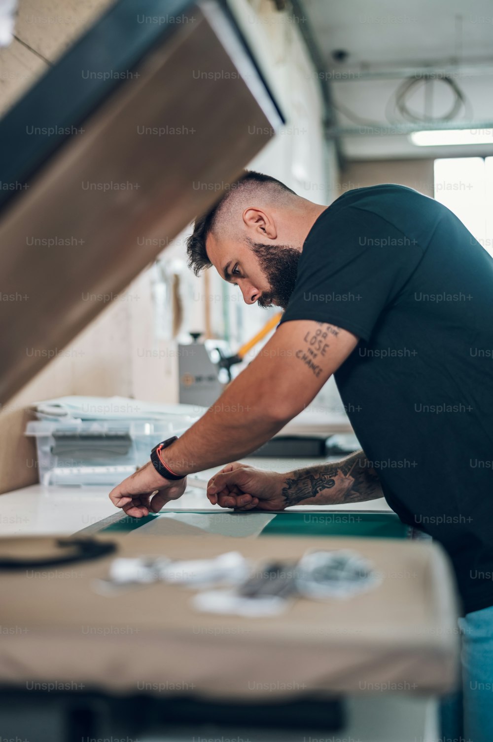 Ouvrier préparant un film de sérigraphie dans un atelier