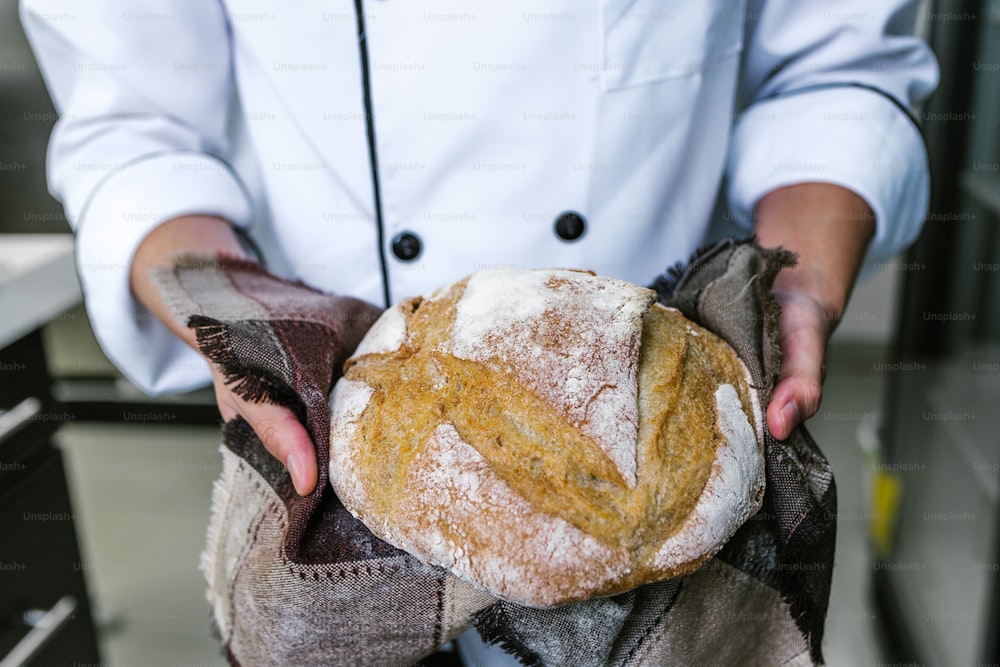 manos de panadero sosteniendo un pedazo de pan en la cocina en México América Latina