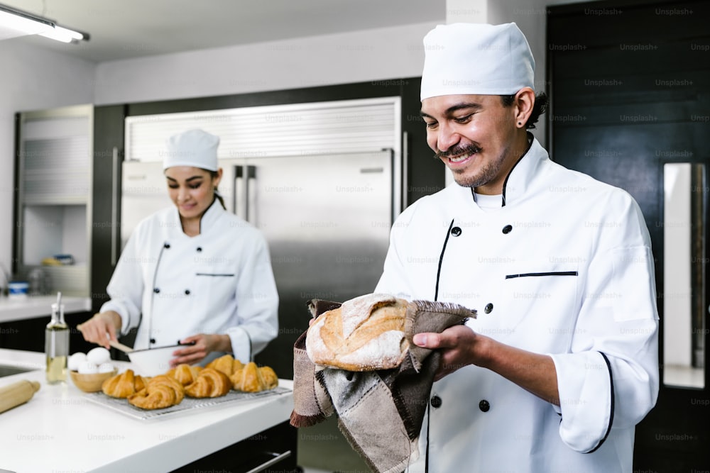 Joven latino panadero y hornear pan en el horno de cocina en México América Latina