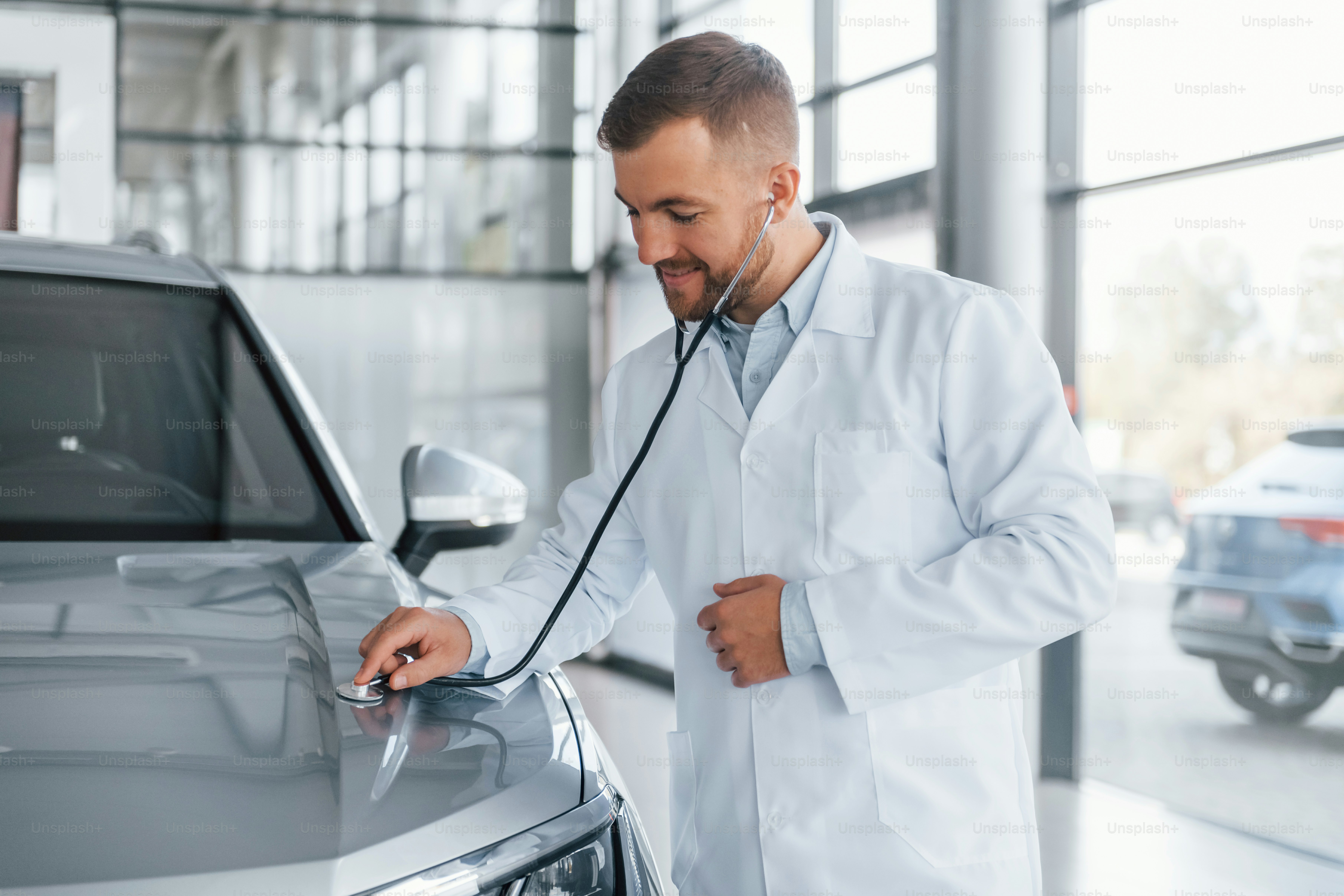Médico de jaleco branco está usando estetoscópio no automóvel.