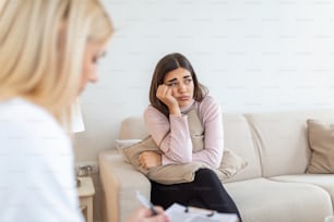 Psychologist listening to her patient and writing notes, mental health and counseling. Psychologist consulting and psychological therapy session concept