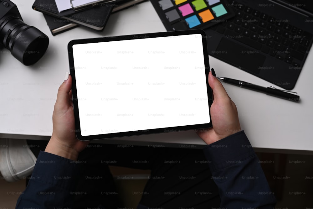 Designer gráfico usando tablet digital enquanto está sentado no local de trabalho criativo.