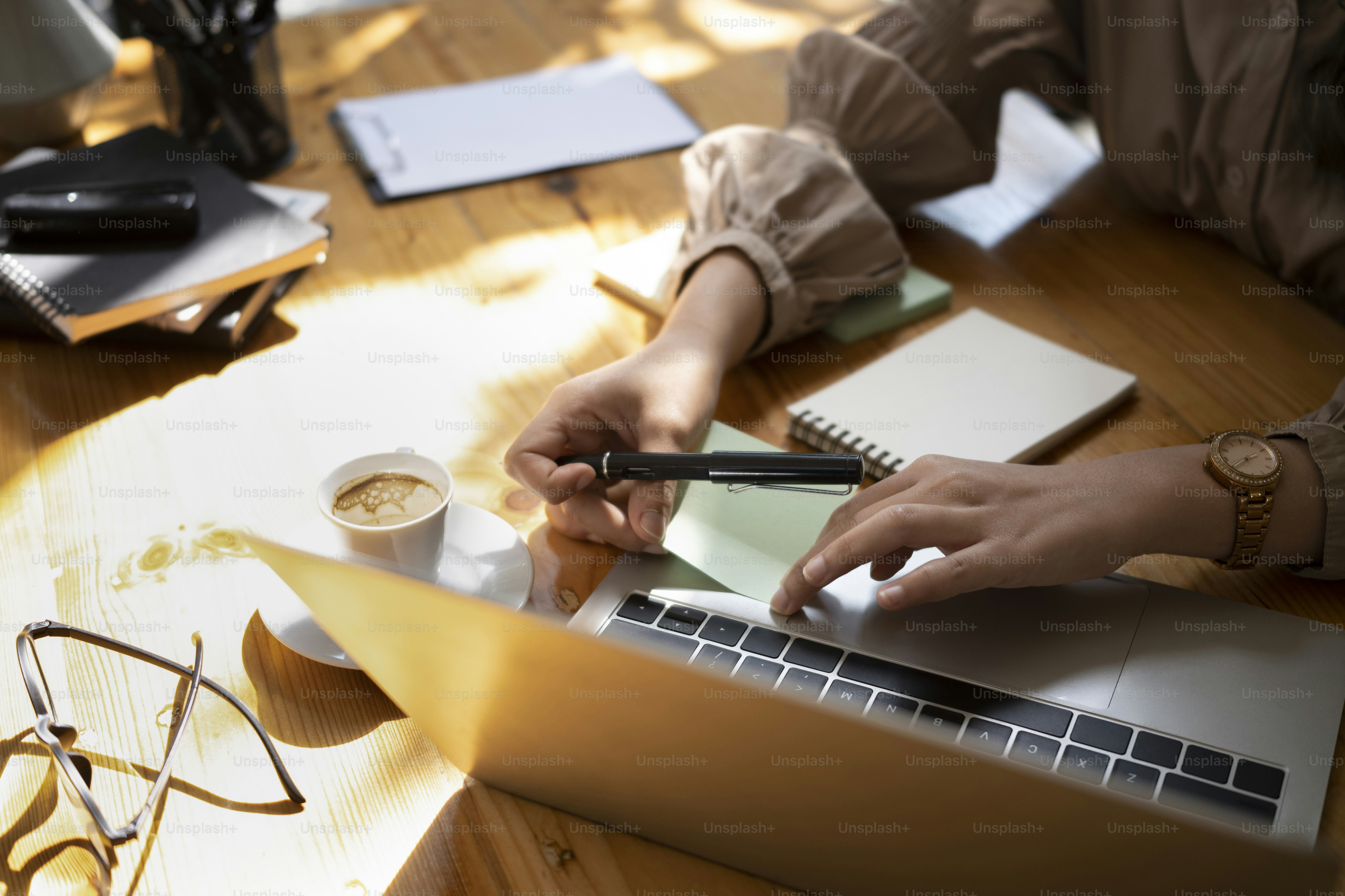 Jeune femme d’affaires rédigeant un plan d’affaires sur un post-it et mettant sur un ordinateur portable.