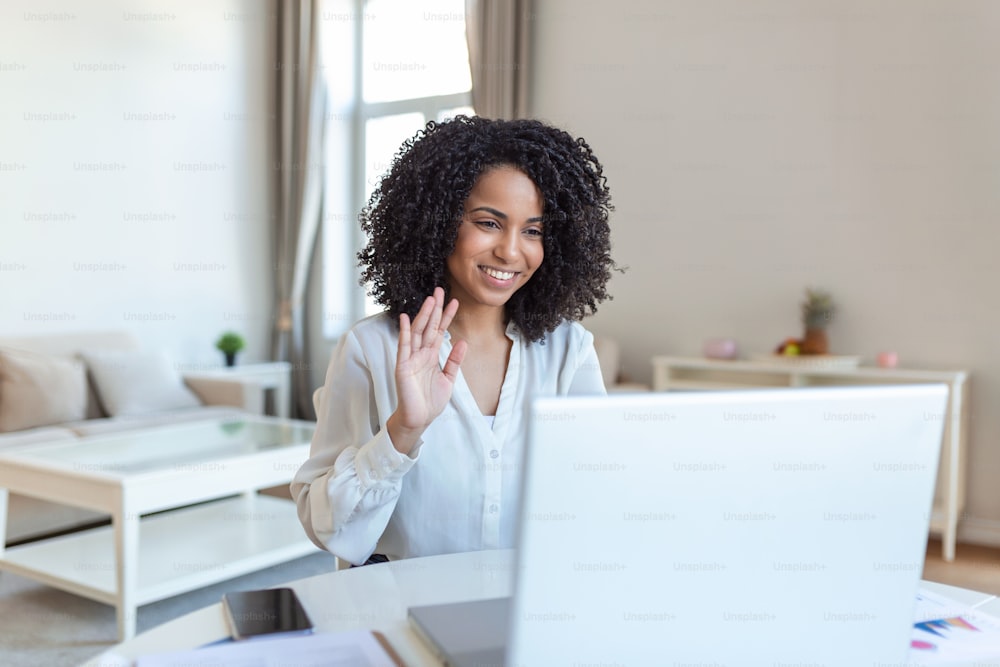 Shot of a businesswoman on a video call while sitting at her desk.Cropped shot of an attractive young woman using her laptop to make a video call at home