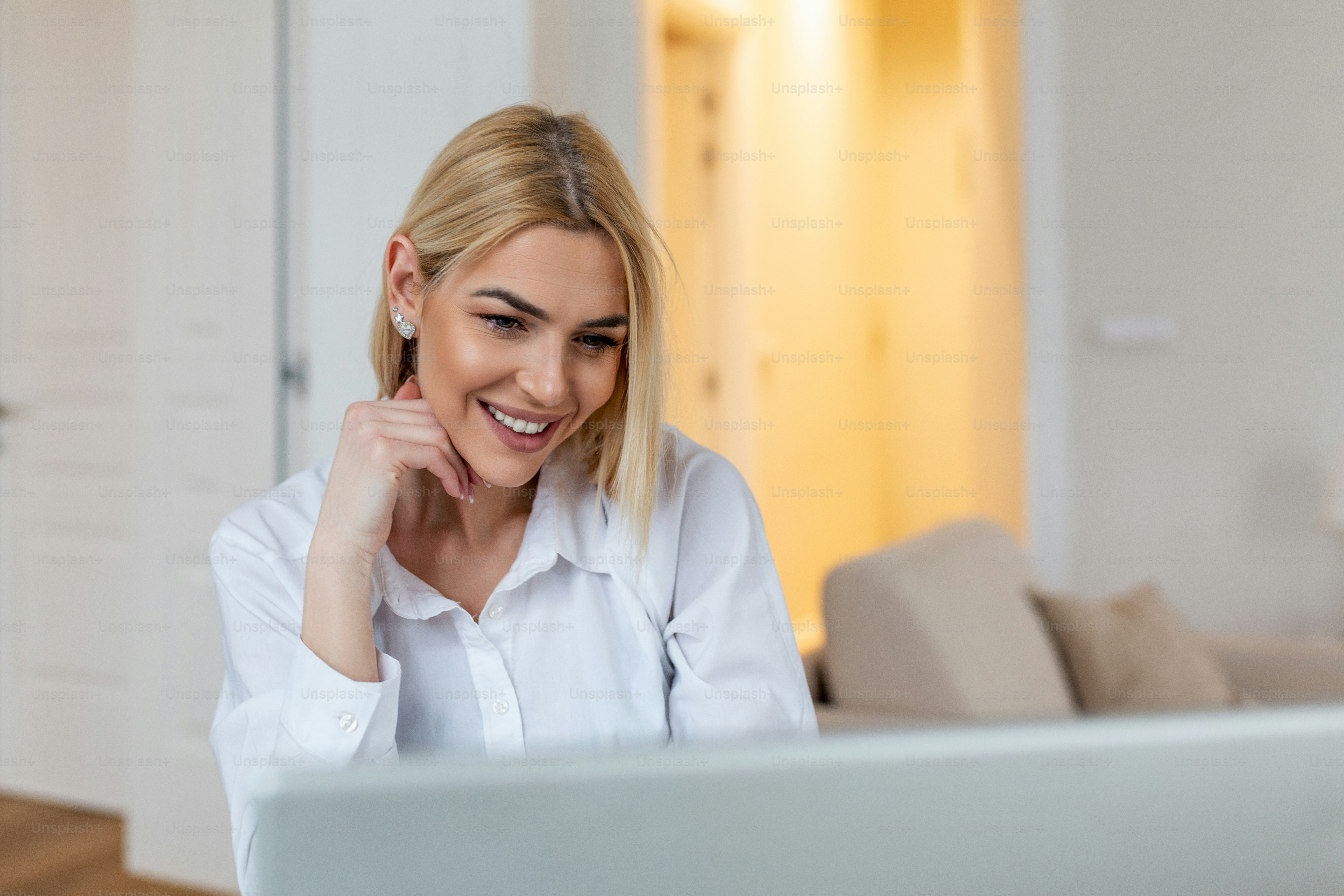 Happy blond woman ooking at webcam, smiling at camera, laughing during virtual meeting or video call talk. Employee working from home. Screen view head shot