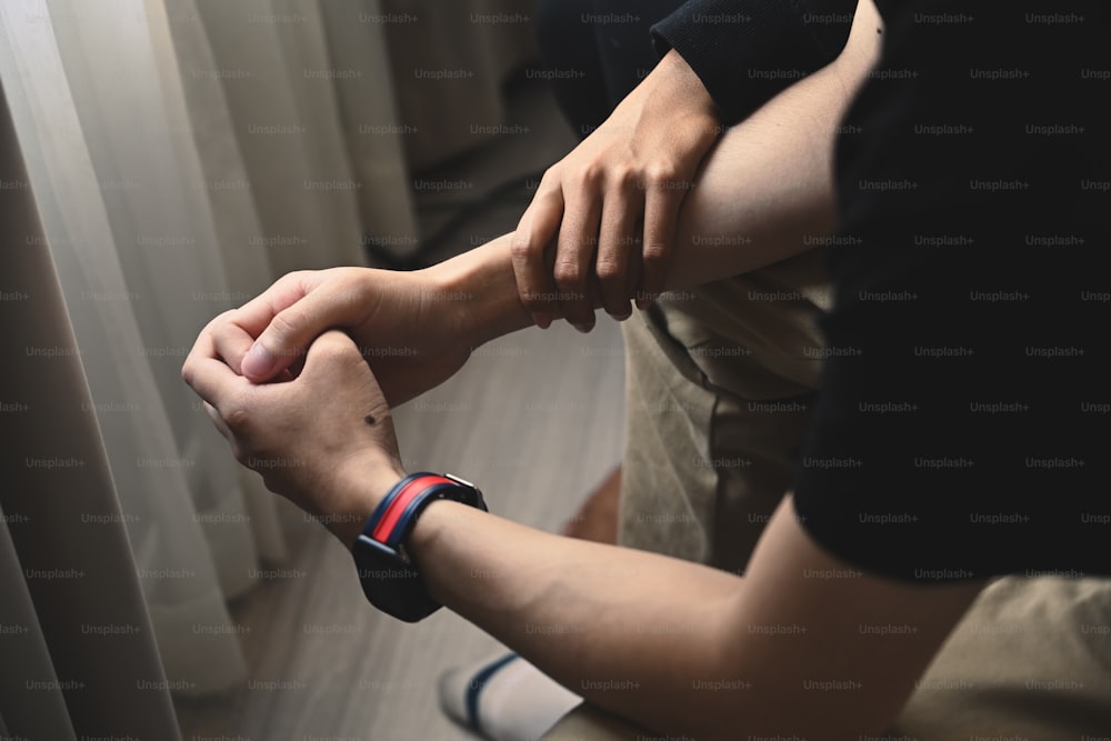 Hands of wife comforting her husband who has depression and some problems.