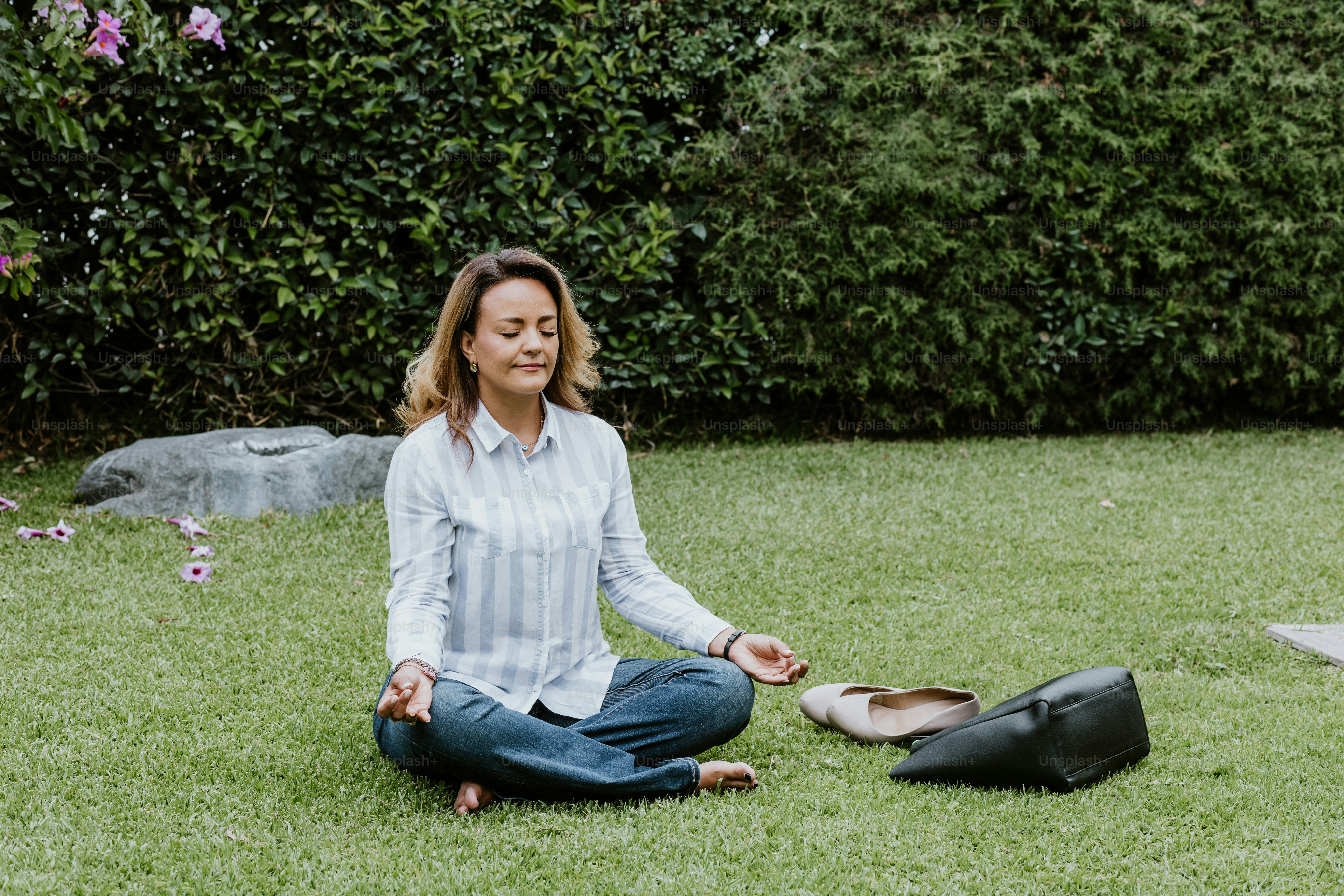 latin business woman sitting on grass and meditating at terrace office in Mexico Latin America