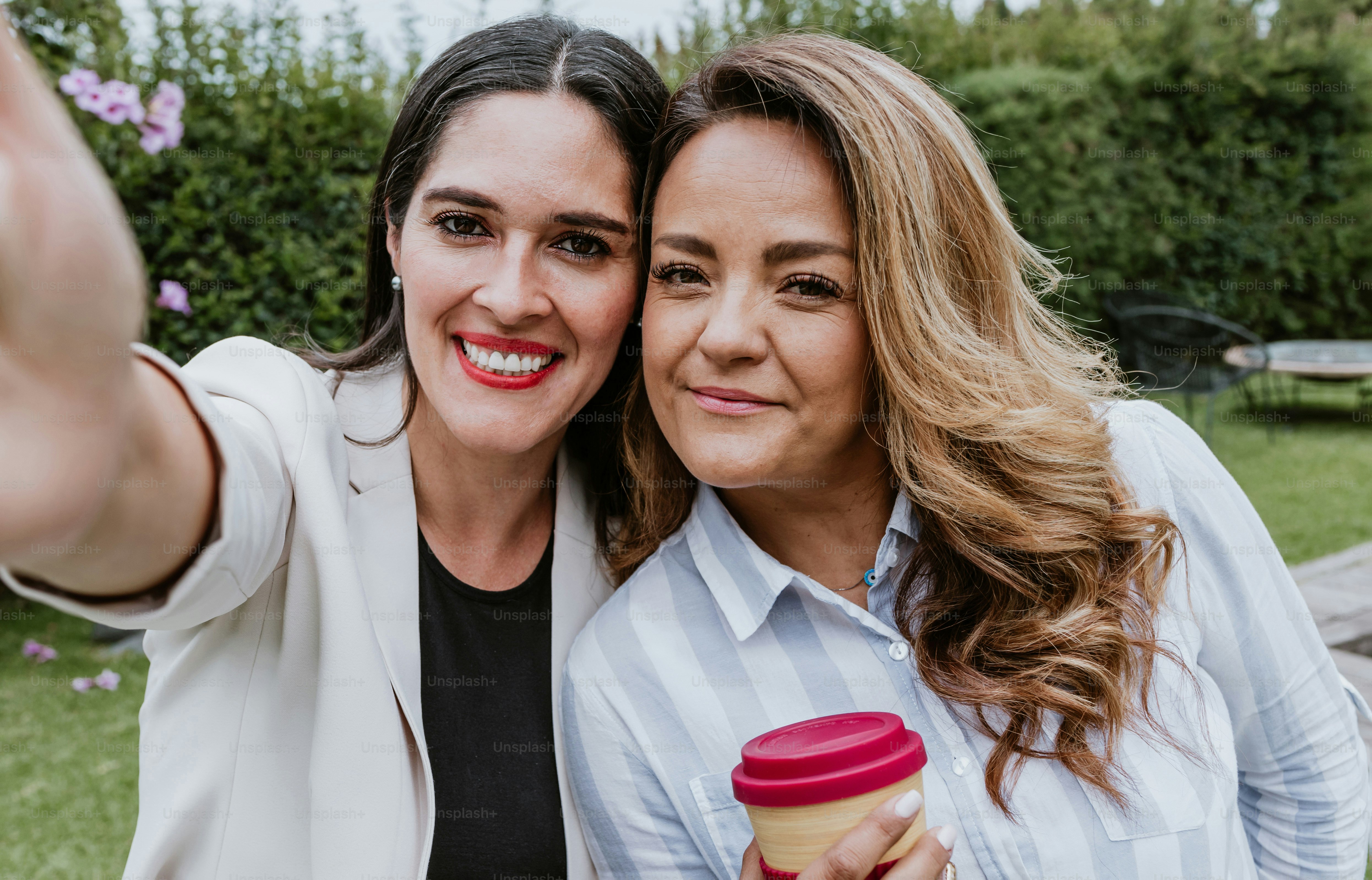 two latin business women taking a photo selfie with mobile phone at terrace office in Mexico Latin America
