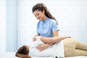 Close up of female osteopath doing shoulder blade therapy on young woman.