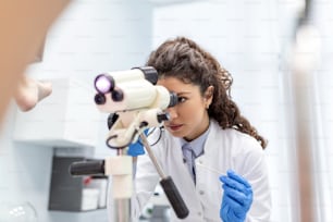 primo piano del colposcopio, immagine di un ginecologo e di una paziente su una poltrona ginecologica. Consulenza per le donne