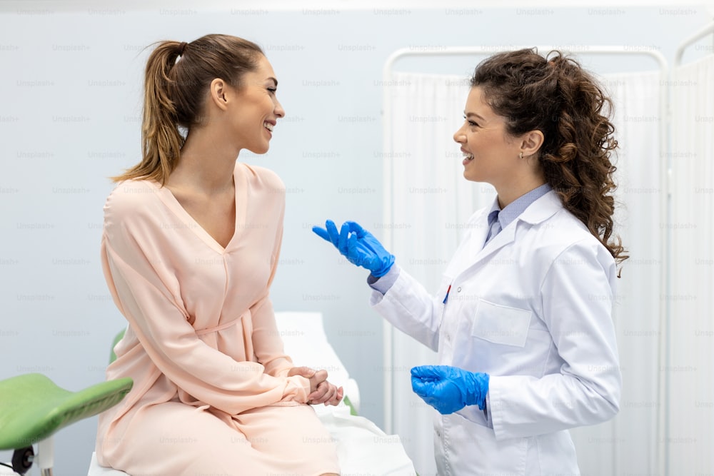 Ginecologo che parla con una giovane paziente durante la consultazione medica in una clinica moderna. Paziente con un ginecologo durante la visita nello studio ginecologico