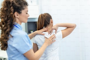 Physiotherapist doing healing treatment on womans back. Back pain patient, treatment, medical doctor, massage therapist.office syndrome