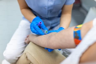 Close up Hand of nurse, doctor or Medical technologist in blue gloves taking blood sample from a patient in the hospital.