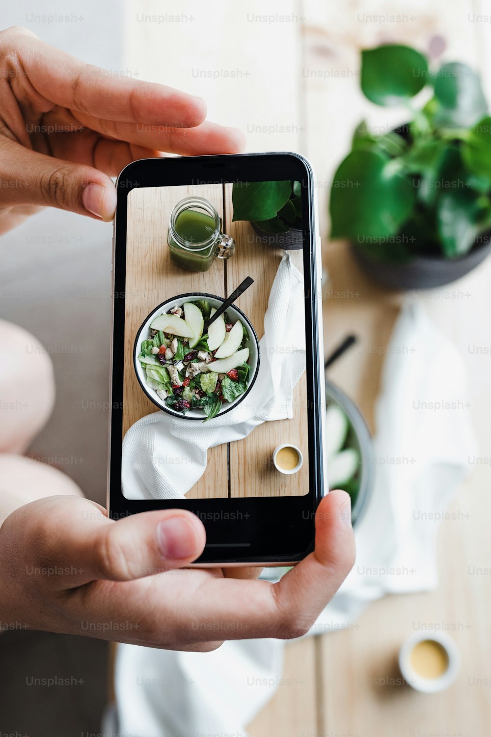 サラダボウルと青汁、携帯電話と木製のテーブルの写真、メキシコラテンアメリカの自宅で健康食品
