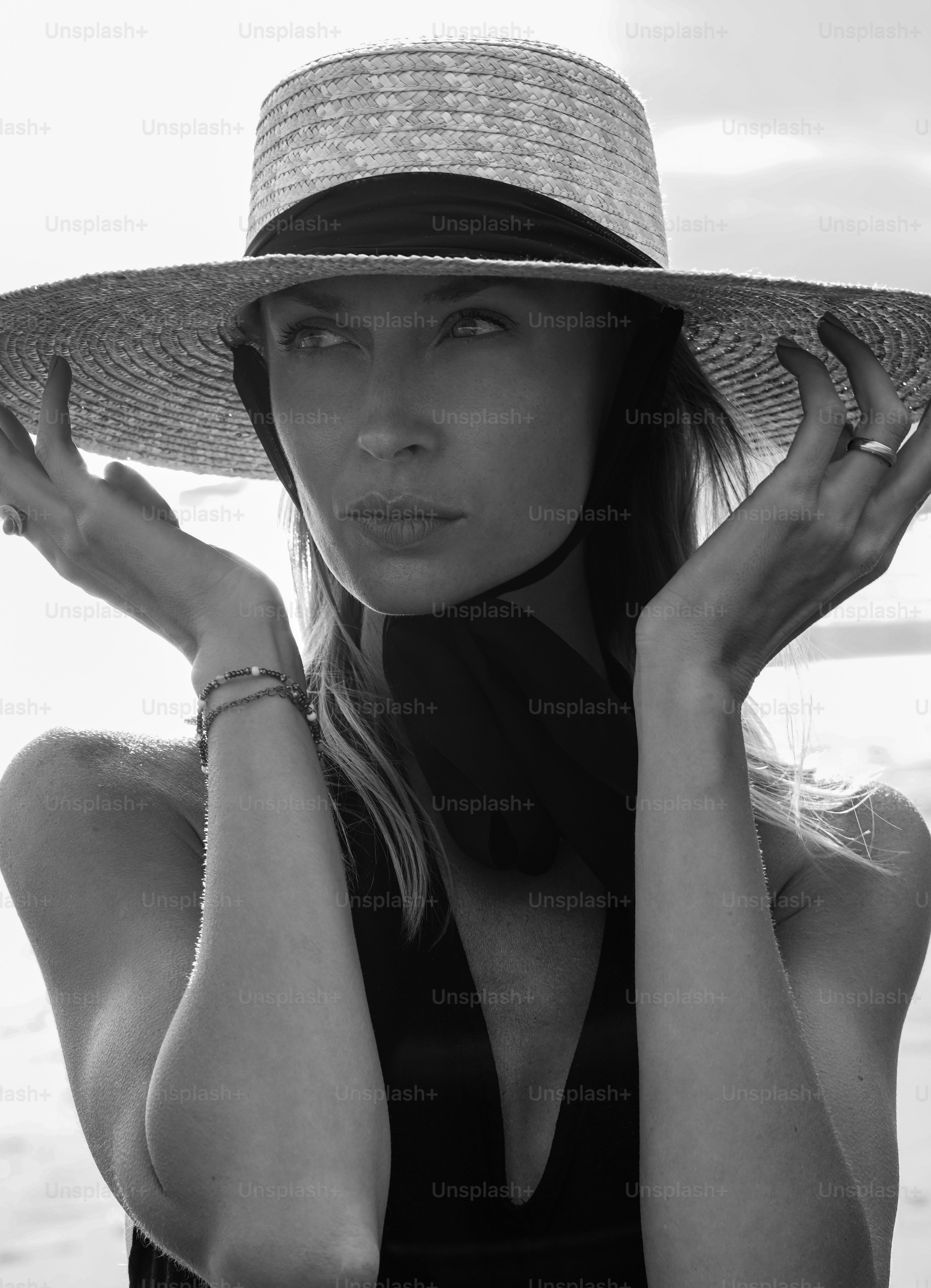 Beauty portrait of fashion young blonde woman in a summer straw hat on the beach image