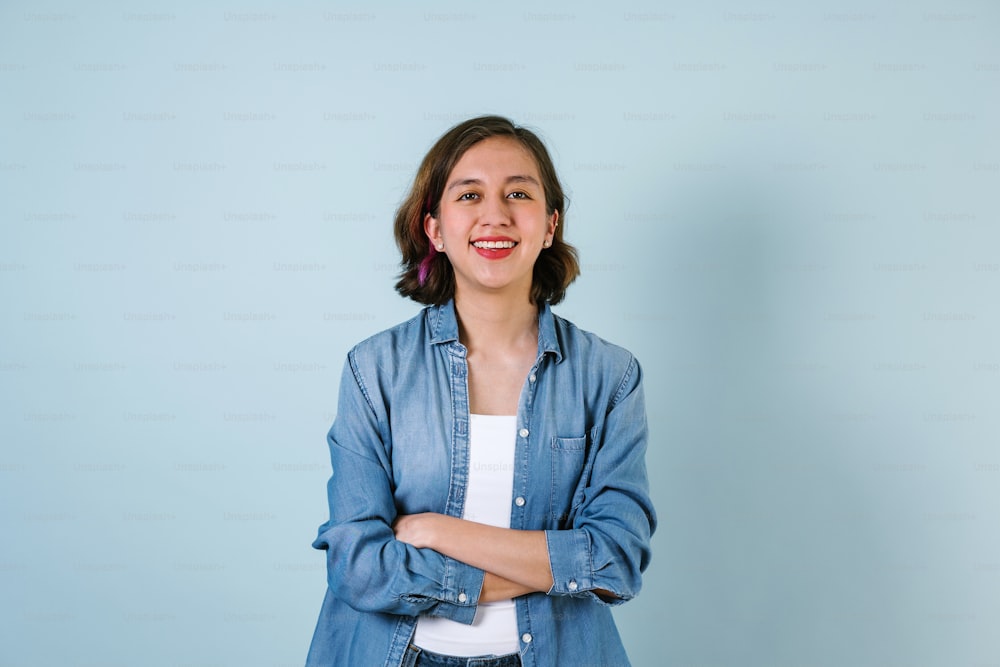 Portrait of hispanic girl smiling looking at camera on blue background in Mexico Latin America