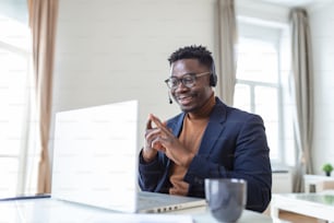Homem afro-americano animado usando fones de ouvido lendo boas notícias no e-mail, conseguindo um novo emprego, promoção, usando laptop, olhando para a tela e gritando de alegria, mostrando sim gesto, celebrando