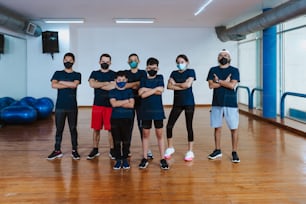 Lateinamerikanische Jugendliche und hispanische Kinder mit Instruktor Mann mit Gesichtsmaske für Coronavirus-Covid-Pandemie im Sportunterricht in Mexiko Lateinamerika