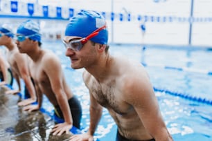 latin young man swimmer wearing cap and goggles in a swimming training at the Pool in Mexico Latin America