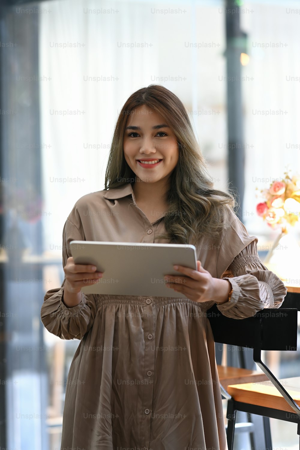 커피숍에 서서 디지털 태블릿을 사용하는 아름다운 여성 기업가의 초상화.